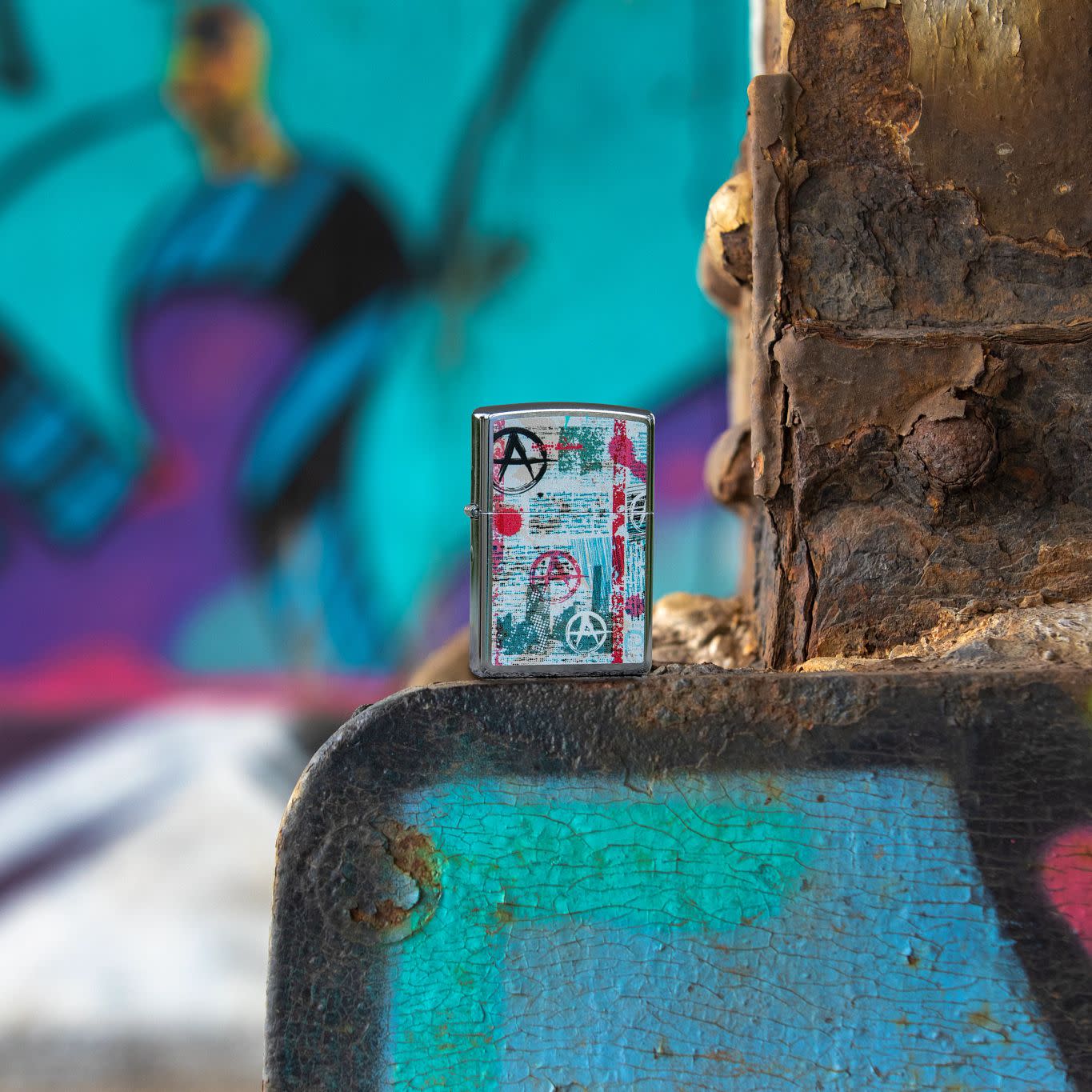 Lifestyle image of Anarchy Design Street Chrome?äó Windproof Lighter, standing in a street with graffiti.